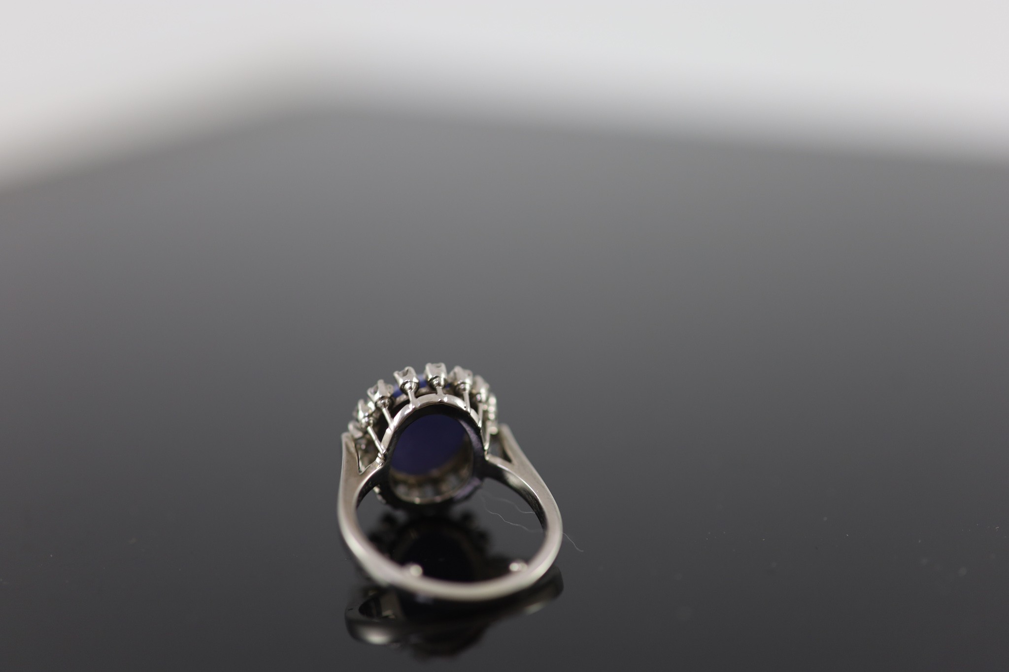 A 14k white gold, cabochon star sapphire and diamond set oval cluster ring